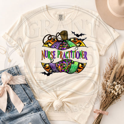 Ivory Comfort Colors short sleeve Nurse Practitioner Halloween shirt with colorful pumpkin and bats graphic, flat lay.