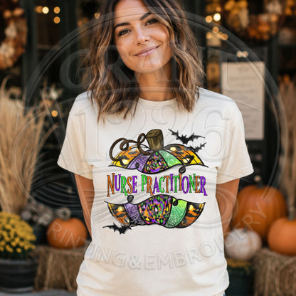 Ivory Comfort Colors short sleeve Nurse Practitioner Halloween shirt with colorful pumpkin and bats graphic, modeled outdoors.