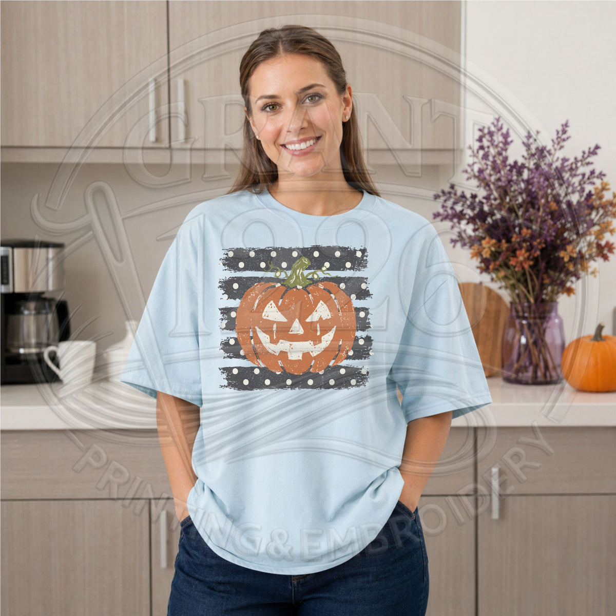 Woman wearing a chambray Comfort Colors Halloween pumpkin shirt with distressed jack o lantern and black polka dot graphic