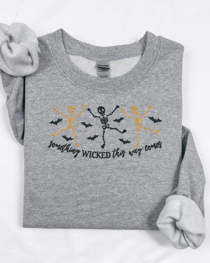 Halloween crewneck featuring embroidered skeletons, flying bats and Something Wicked phrase