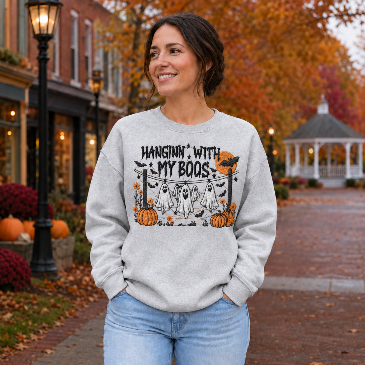 Woman wearing a Sport Grey Hanging With My Boos embroidered Halloween sweatshirt with hanging ghosts