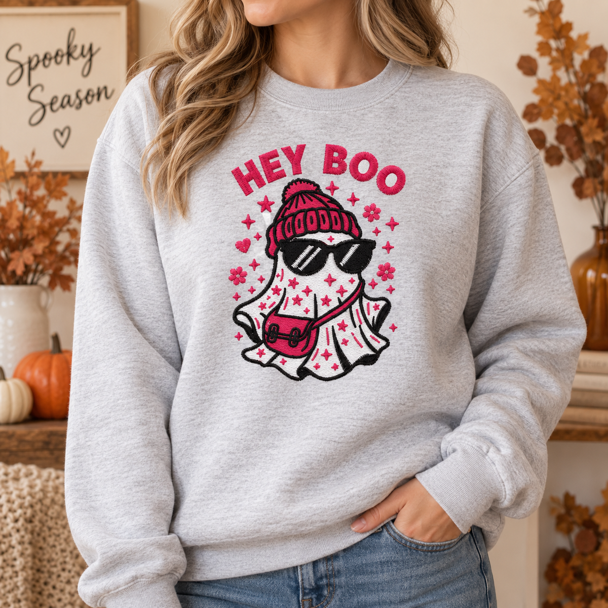 Woman wearing an ash Hey Boo fashion ghost embroidered Halloween sweatshirt