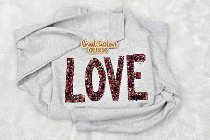 Close-up of pink sequin Love embroidery on sweatshirt