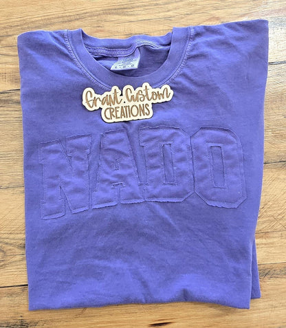 Flat lay of custom applique shirt styled on wood background