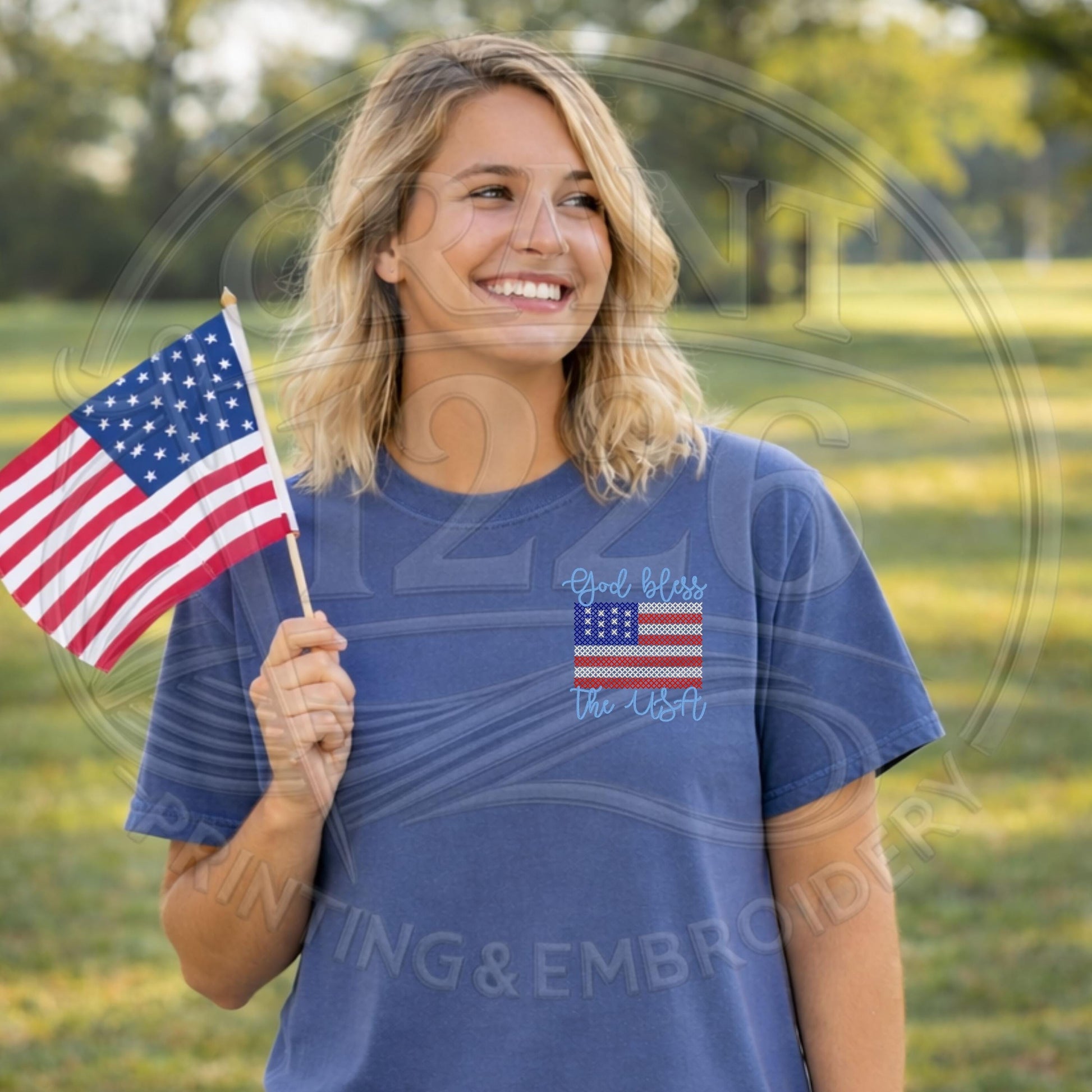 Woman wearing blue patriotic Comfort Colors shirt while holding an American flag