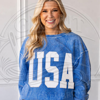 Blue corded sweatshirt with solid white USA applique letters stitched across the front for a clean patriotic look.