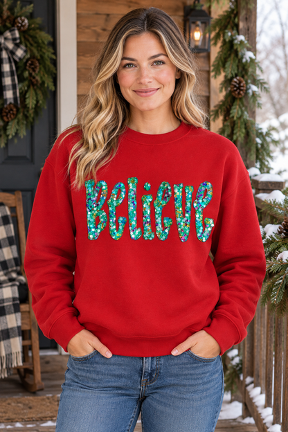 Winter porch mockup of a model wearing a red Believe sequin Christmas sweatshirt