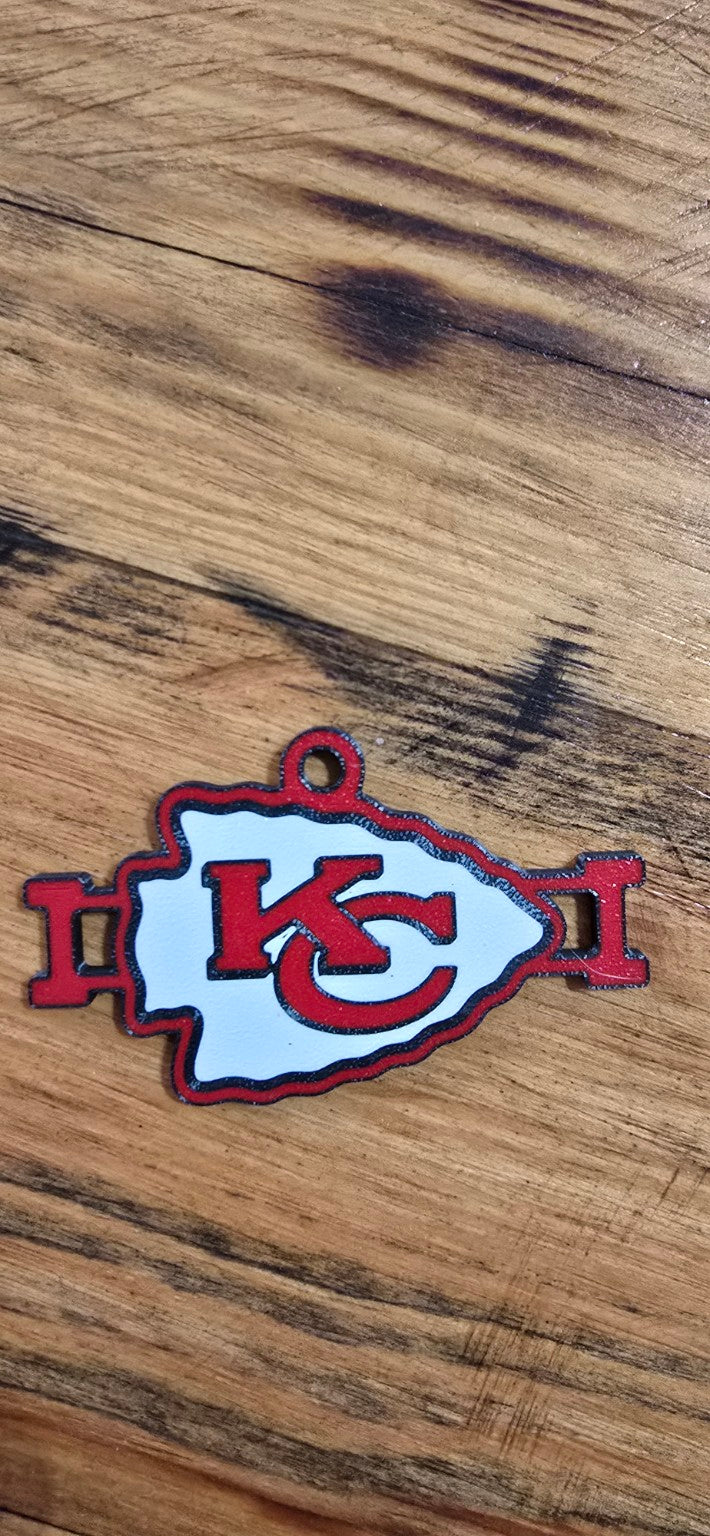 Red, white, and black Kansas City football arrowhead hair tie holder on a wood background