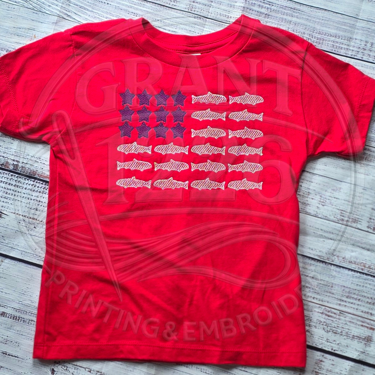 Red kids patriotic fish flag embroidered T-shirt flat lay