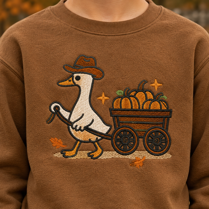 Close-up raised embroidery detail of pumpkin wagon goose on Coyote Brown youth sweatshirt