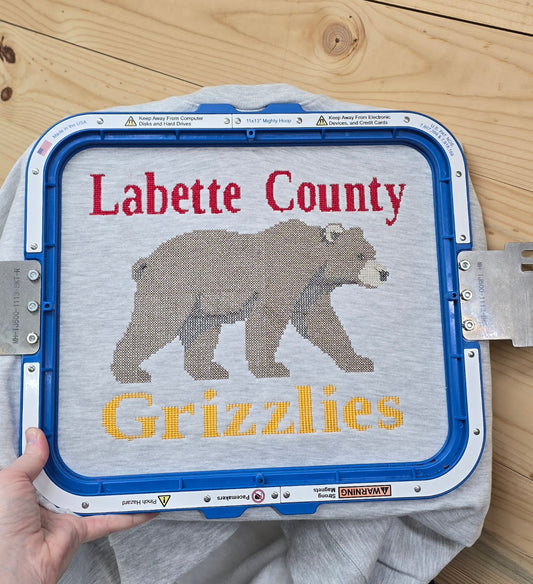 Close-up of Labette County Grizzlies bear embroidery on an ash grey sweatshirt
