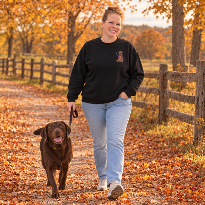 Woman walking a chocolate Lab in autumn while wearing a black embroidered Labrador sweatshirt