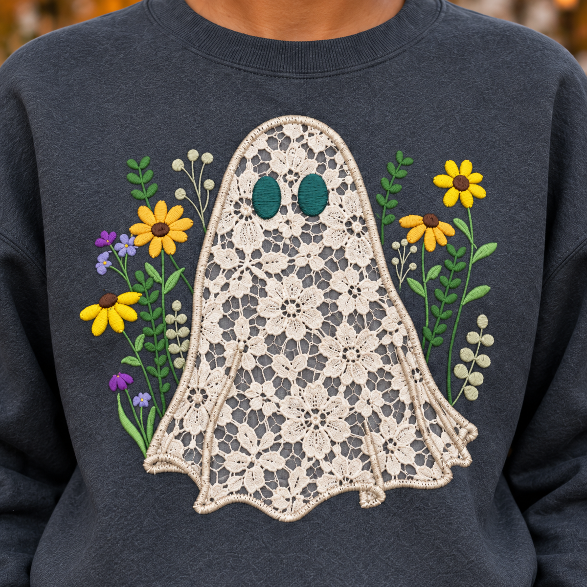 Close-up of ivory floral lace ghost appliqué, satin stitched edge and colorful wildflower embroidery