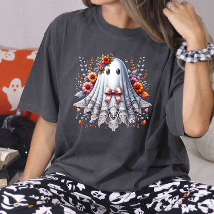 Woman wearing a Pepper Comfort Colors lace ghost Halloween shirt with a pink bow and fall florals