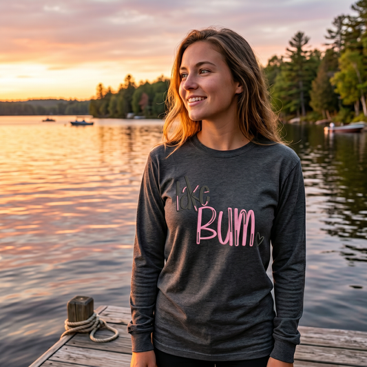 Woman wearing charcoal embroidered Lake Bum long sleeve lake life shirt at sunset
