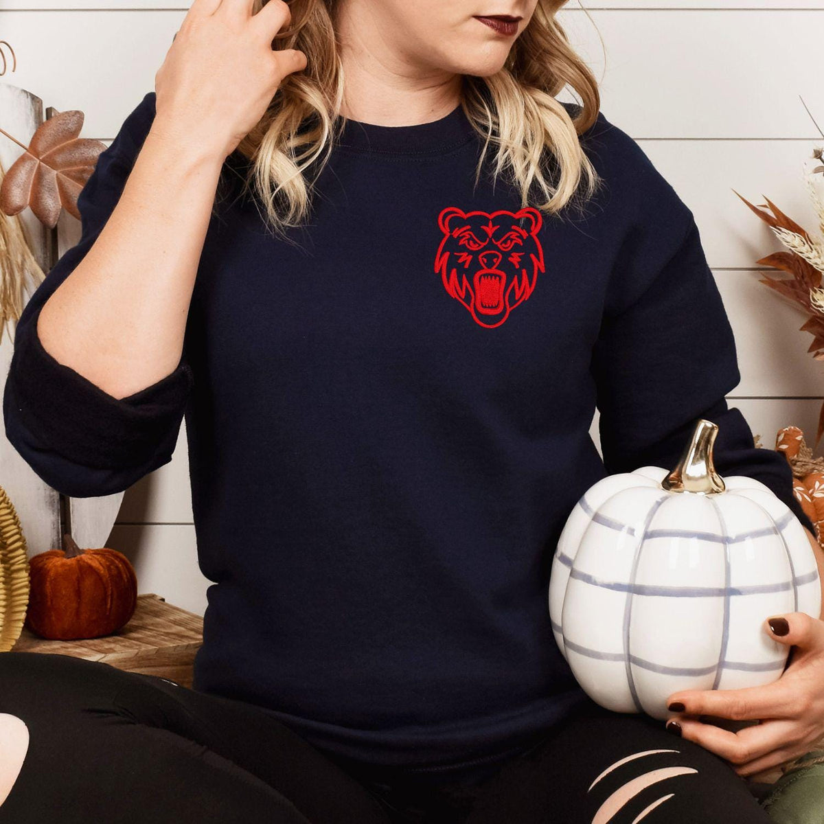 Navy sweatshirt with red left-chest bear mascot embroidery modeled indoors