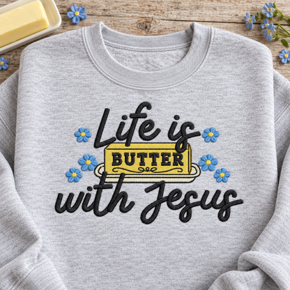 Close-up of Life Is Butter With Jesus embroidery with yellow butter and blue flowers
