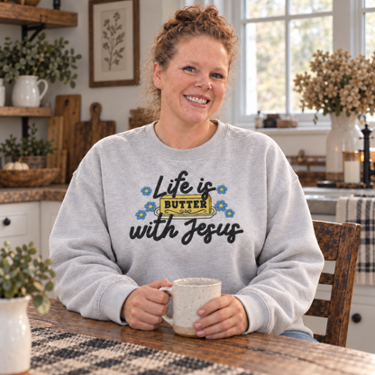Woman seated in a farmhouse kitchen wearing an Ash Life Is Butter With Jesus embroidered sweatshirt