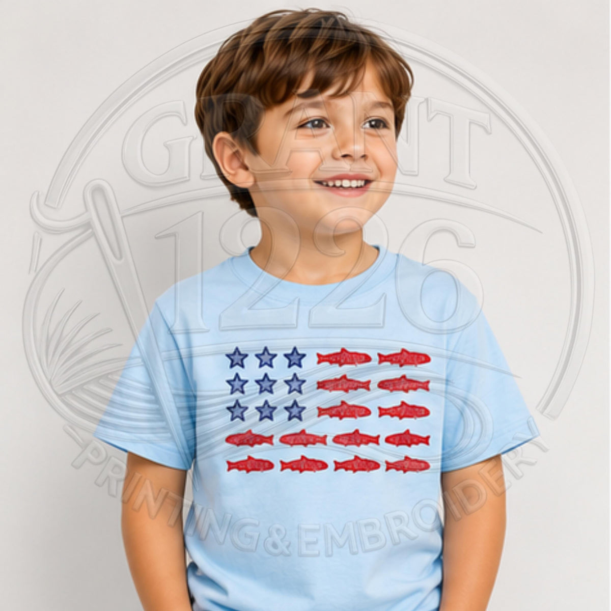 Light blue youth shirt with patriotic embroidered fish flag design.