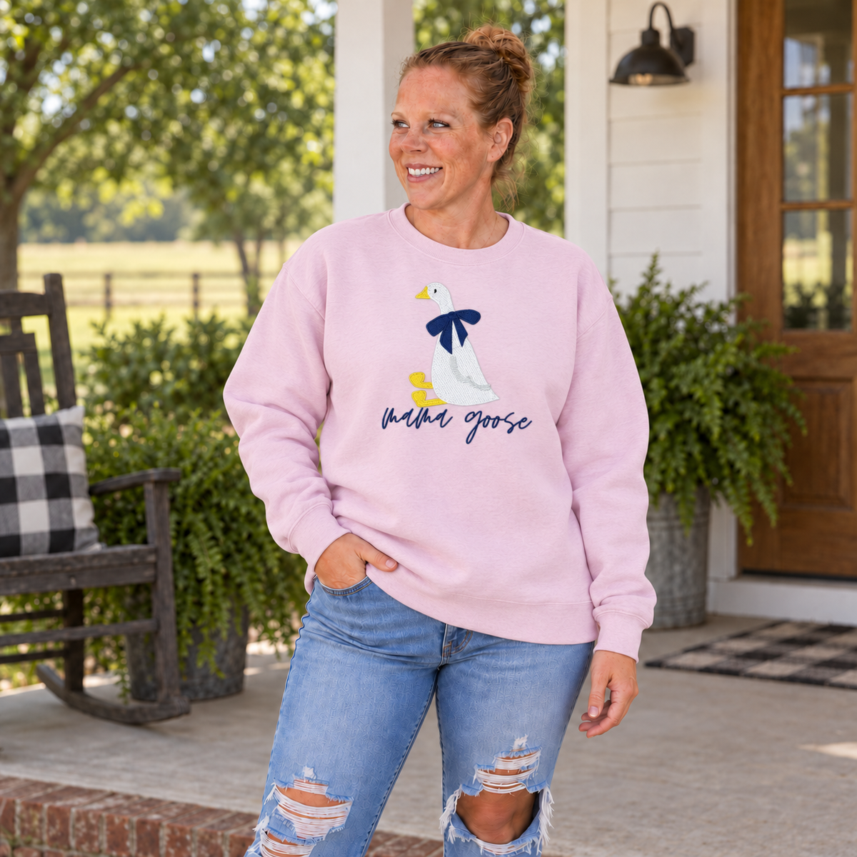 Mama Goose embroidered Gildan Softstyle sweatshirt modeled by Samantha on a green farmhouse porch