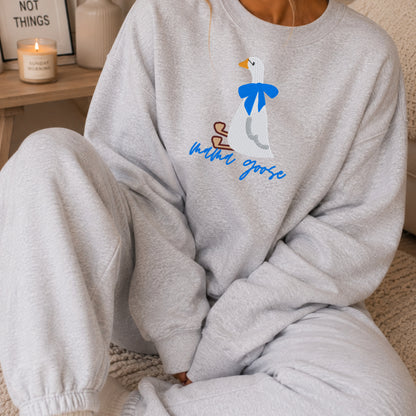 Close-up of the Mama Goose embroidery on an ash gray crewneck sweatshirt with matching gray sweatpants.