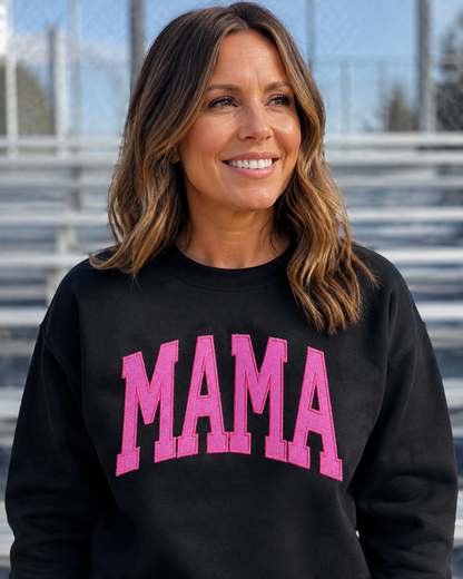 Black MAMA sweatshirt with hot pink glitter vinyl appliqué at a ballfield lifestyle mockup