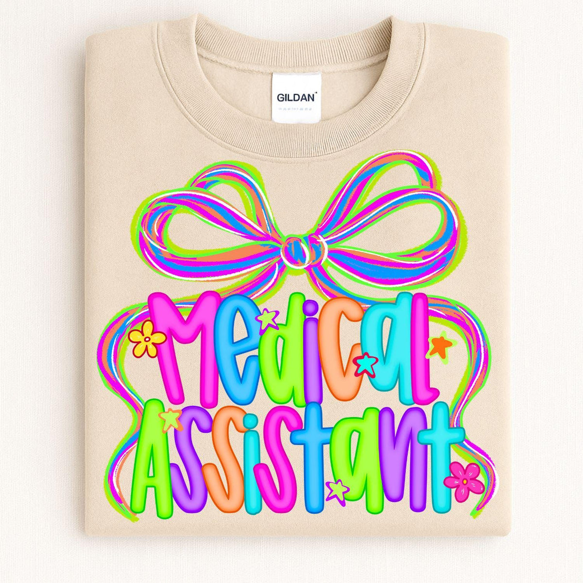 Sand Medical Assistant neon bow sweatshirt folded on a light background
