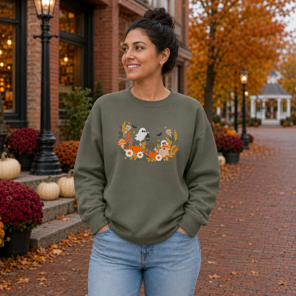 Woman wearing a Military Green floral ghost embroidered Halloween sweatshirt on a fall street