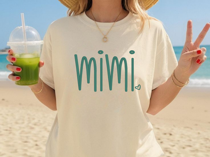 Person wearing a 'mimi' shirt on a beach