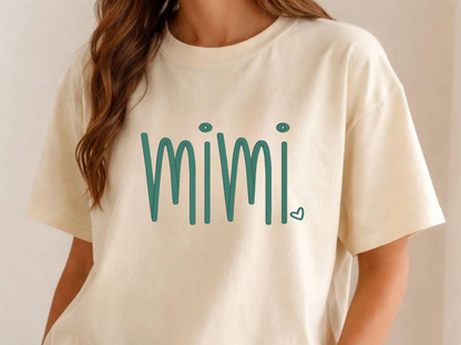 Beige t-shirt with 'mimi' embroidered in teal on a plain background