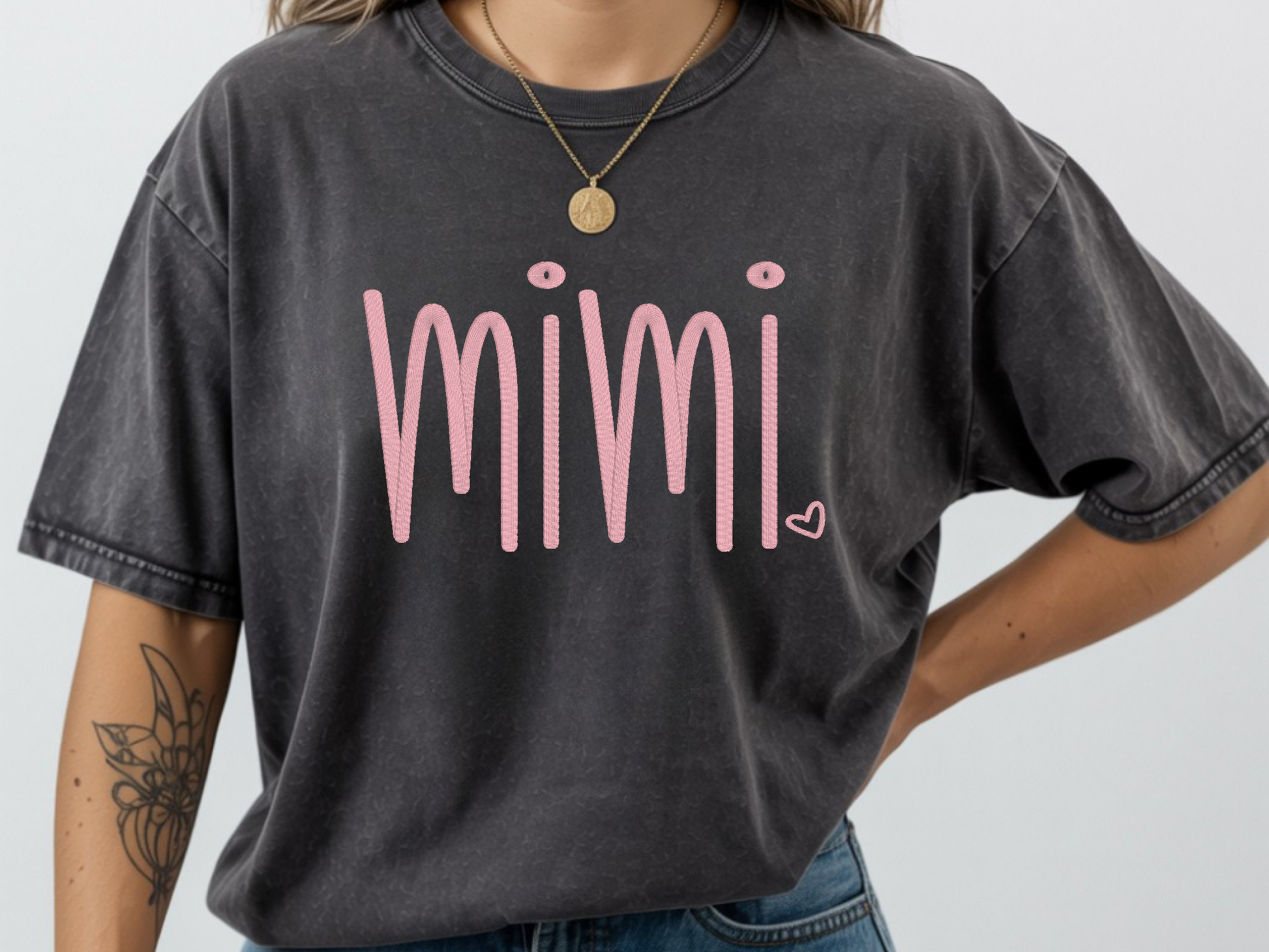 Person wearing a pepper t-shirt with 'mimi' in pink embroidery