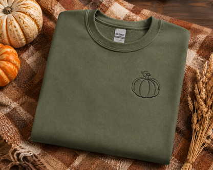 Military Green Gildan Softstyle sweatshirt flat lay with small black pumpkin embroidery and fall decor
