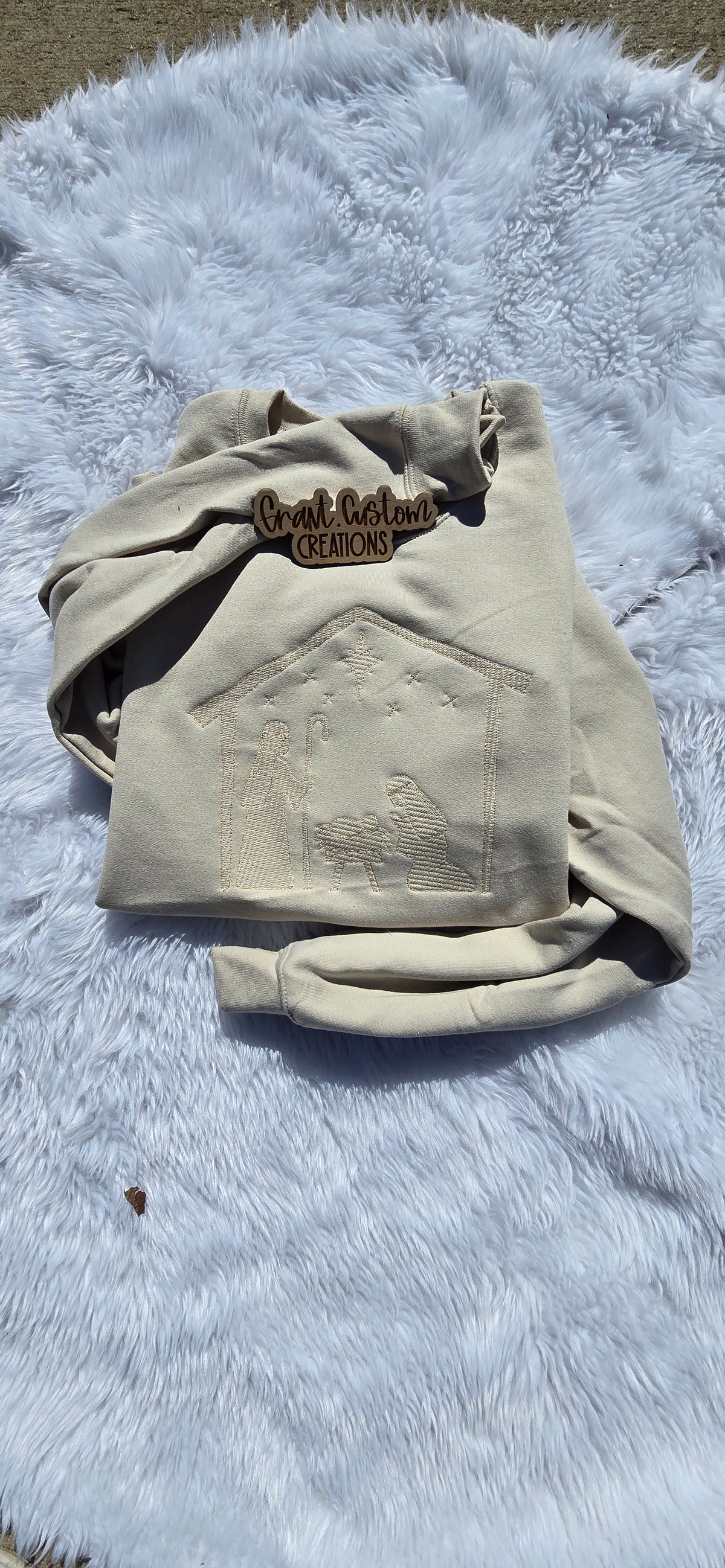 Close-up of tone-on-tone Nativity embroidery stitched on Sand sweatshirt