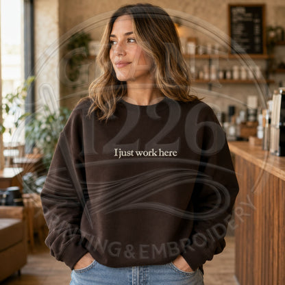 Chocolate brown embroidered work humor sweatshirt worn in cafe
