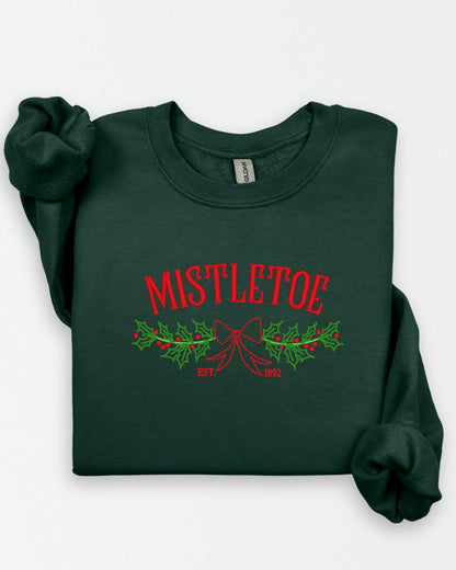 Close-up of mistletoe embroidery stitching on a Christmas crewneck sweatshirt