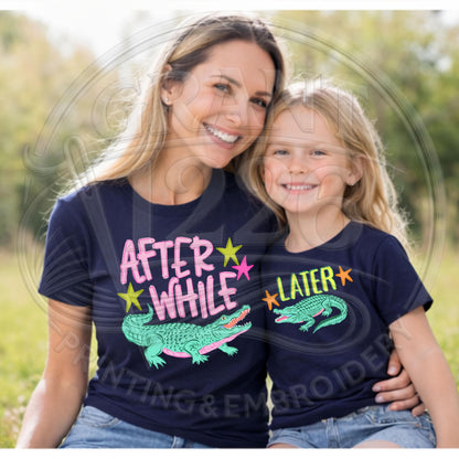 Mom and daughter wearing navy matching alligator shirts outdoors