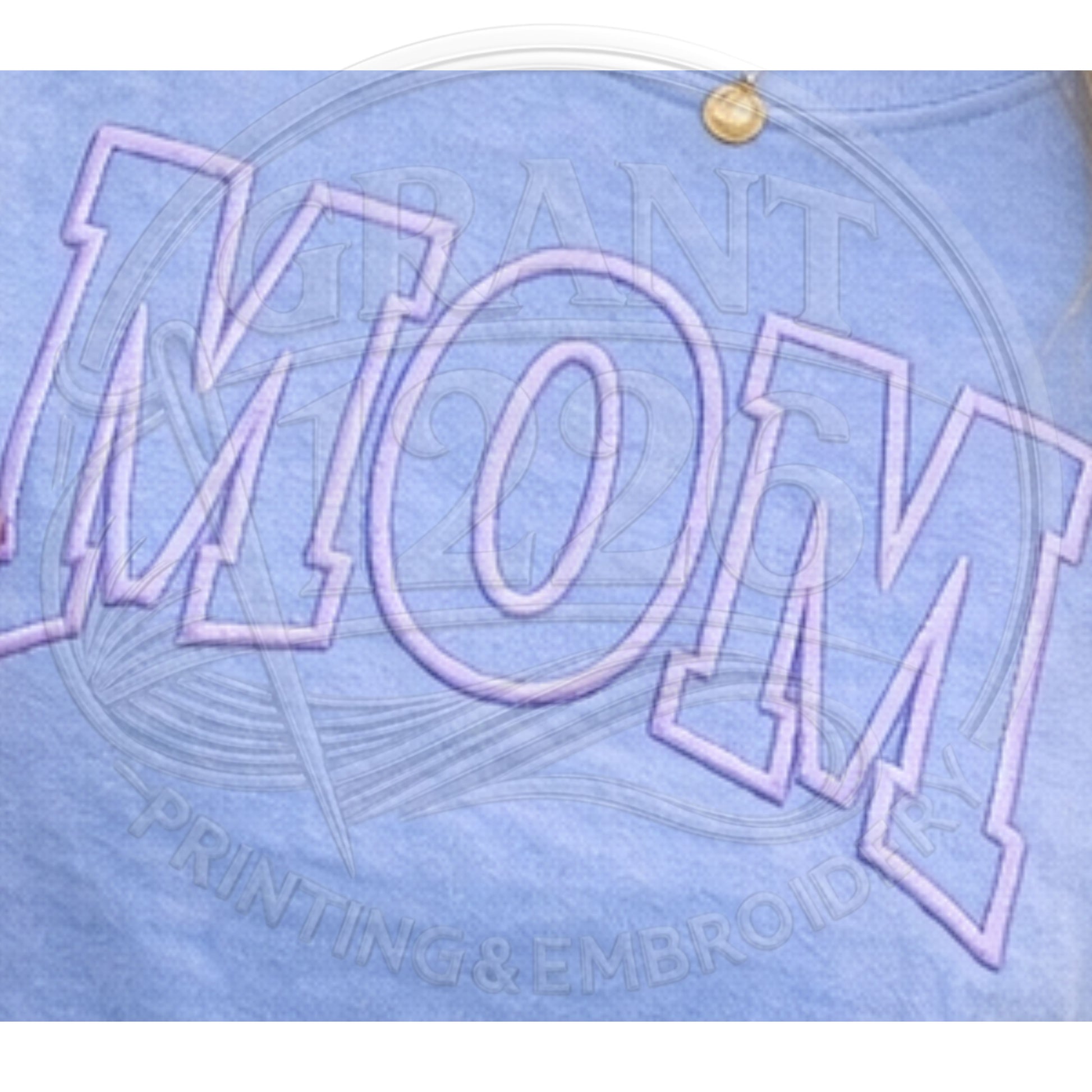 Close up detail of puff embroidered MOM varsity lettering on blue Comfort Colors shirt