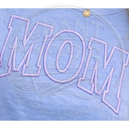 Close up detail of puff embroidered MOM varsity lettering on blue Comfort Colors shirt