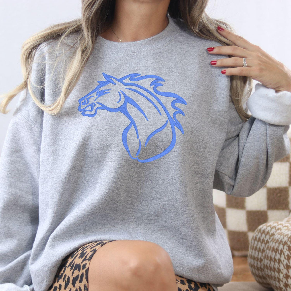 Sport gray Mustang mascot embroidered sweatshirt modeled indoors
