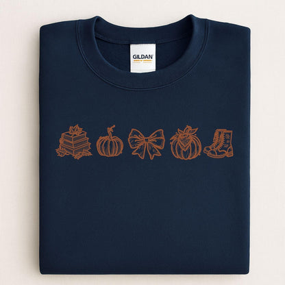 Navy Gildan sweatshirt with a brown embroidered row of fall books and pumpkins