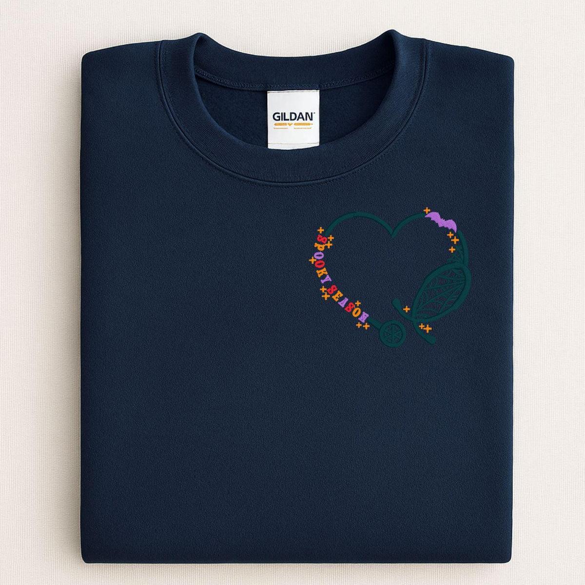 Folded Navy sweatshirt with Spooky Season stethoscope heart embroidery