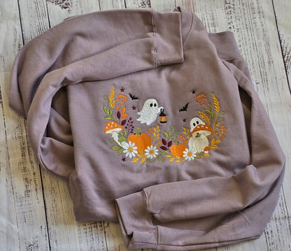 Close-up of floral ghost pumpkin and mushroom embroidery on Paragon Halloween sweatshirt