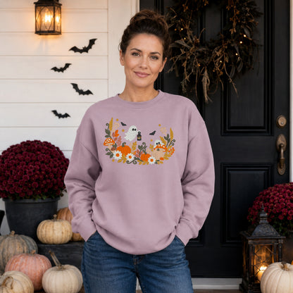 Woman wearing a Paragon floral ghost embroidered Halloween sweatshirt on a pumpkin porch