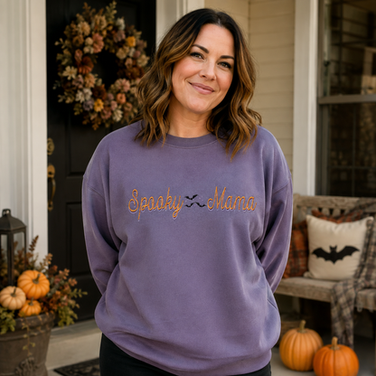 Woman wearing Paragon Spooky Mama embroidered Halloween sweatshirt on a fall porch