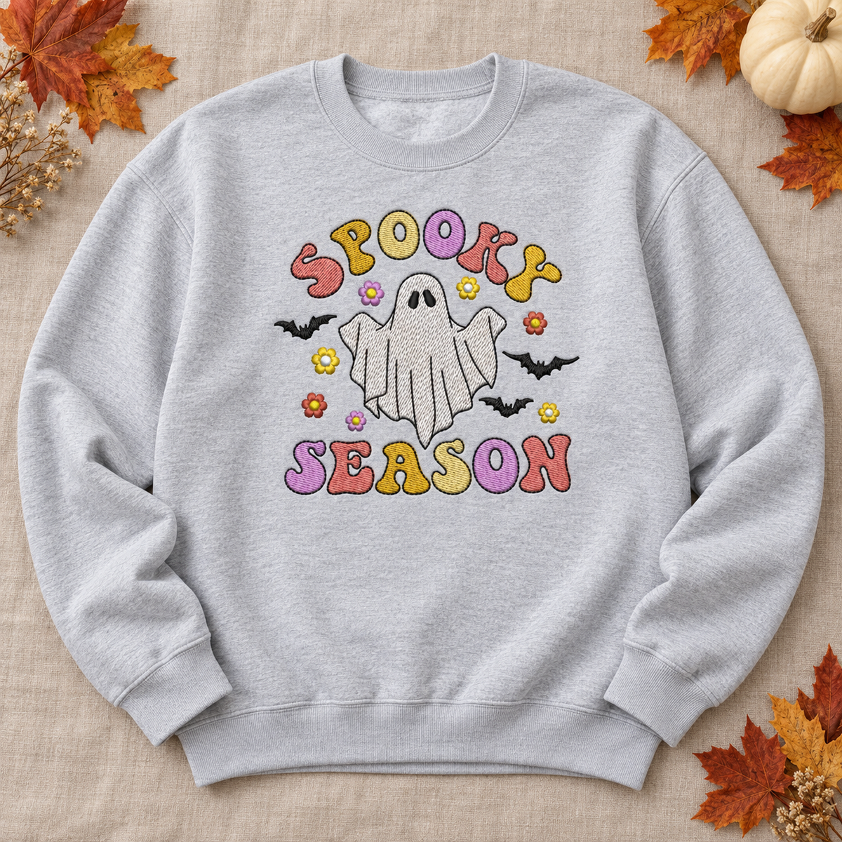 Sport Grey Spooky Season ghost embroidered sweatshirt flat lay with pastel lettering and autumn leaves