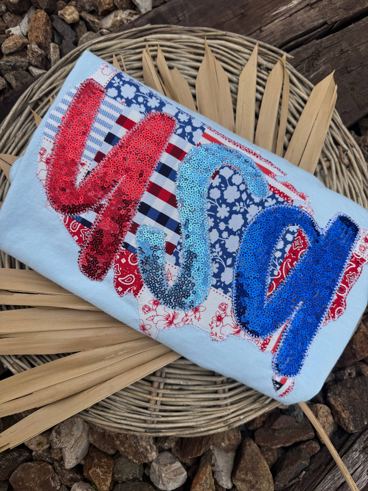 Close-up of a patchwork USA patriotic graphic on a light blue shirt