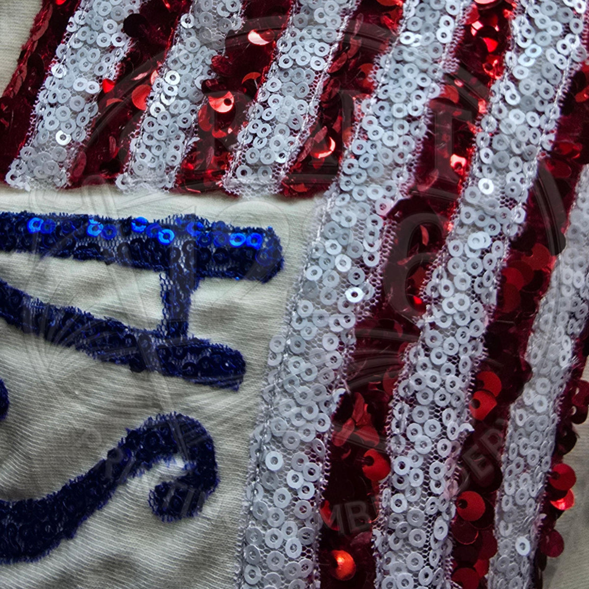 Close-up detail of blue sequin embroidered USA lettering and red white sequin American flag applique.