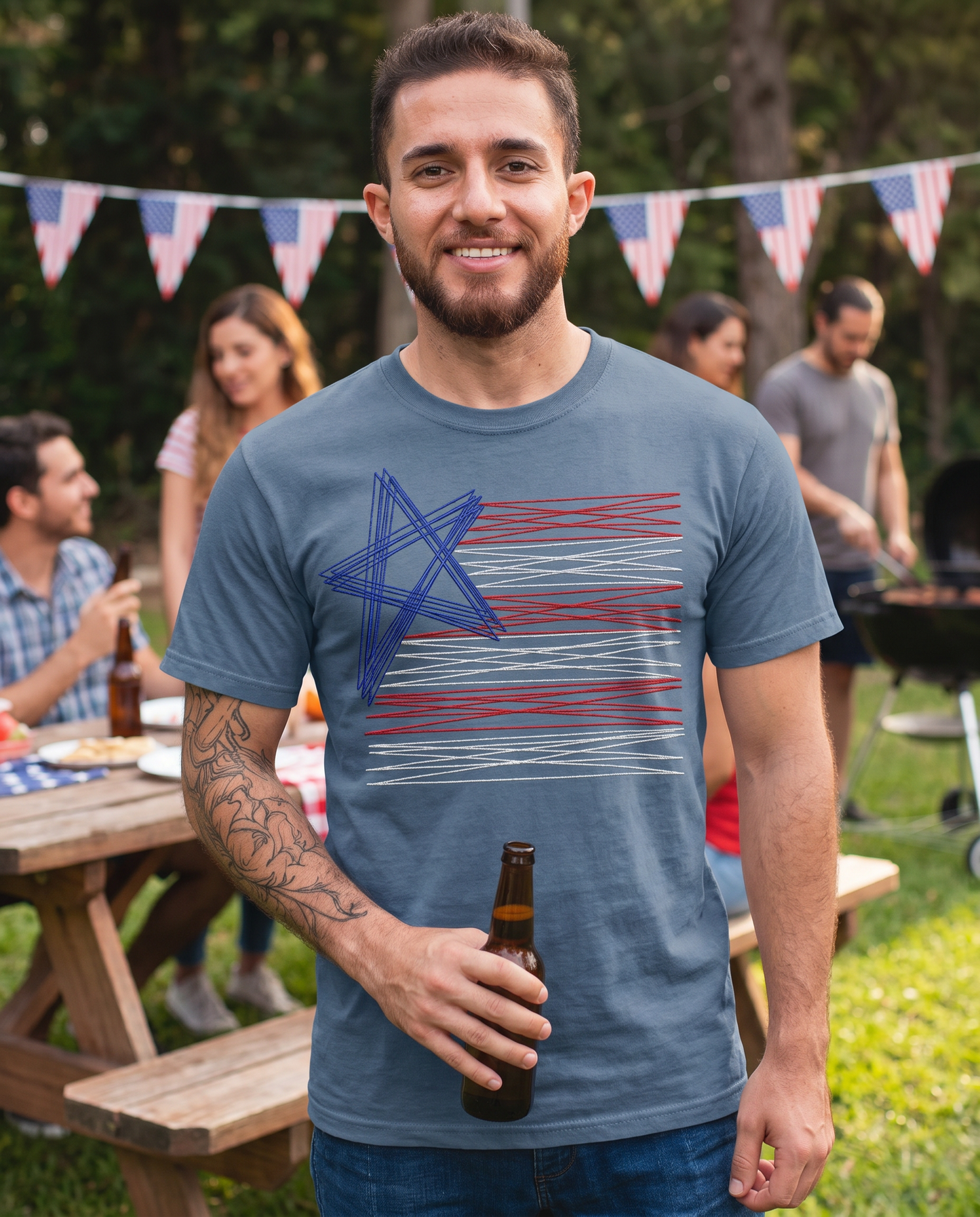 Man wearing blue embroidered American flag graphic tee at patriotic cookout