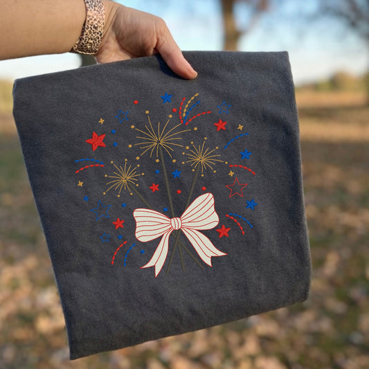 Pepper Comfort Colors T-shirt with embroidered patriotic fireworks and bow design