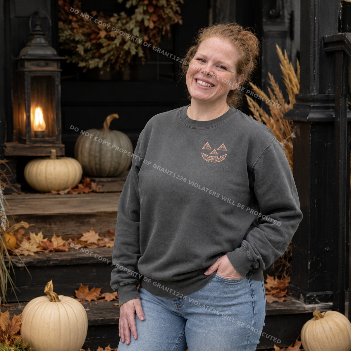 Pepper embroidered pumpkin face sweatshirt styled on a dark farmhouse porch